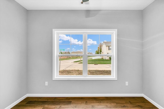 empty room featuring plenty of natural light and hardwood / wood-style flooring