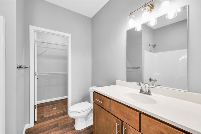 bathroom with hardwood / wood-style floors, vanity, and toilet