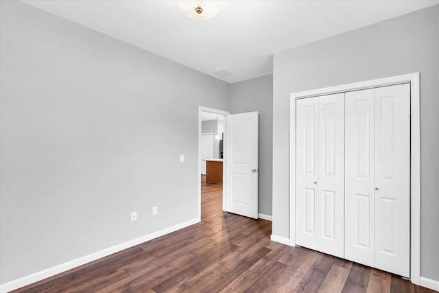 unfurnished bedroom featuring a closet and dark hardwood / wood-style floors