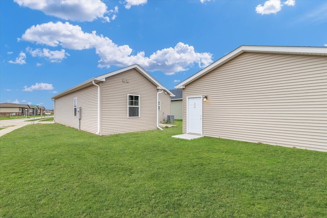 back of property featuring a lawn and central AC unit