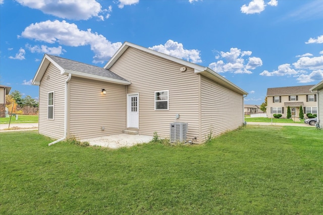 back of property featuring a lawn and central AC