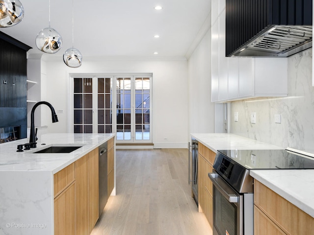 kitchen with stainless steel appliances, ornamental molding, light stone counters, light wood-type flooring, and sink