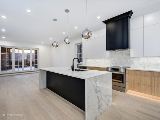 kitchen featuring white cabinets, light hardwood / wood-style flooring, range, and sink