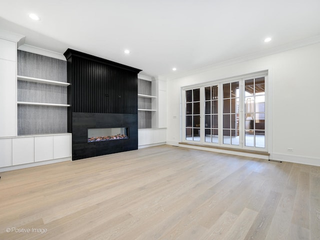 unfurnished living room featuring ornamental molding, light wood-type flooring, and a multi sided fireplace