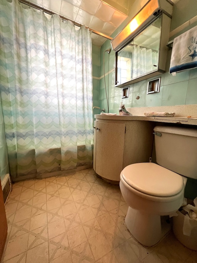 bathroom featuring toilet, tile floors, and vanity