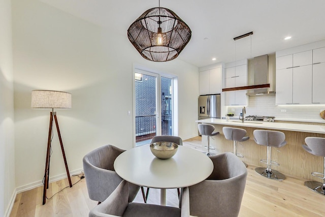 dining area featuring sink and light hardwood / wood-style floors