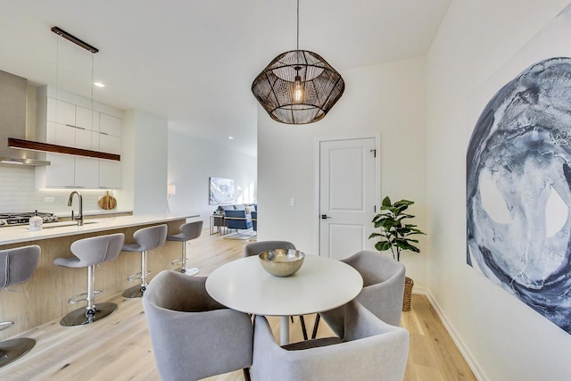 dining area with sink and light wood-type flooring