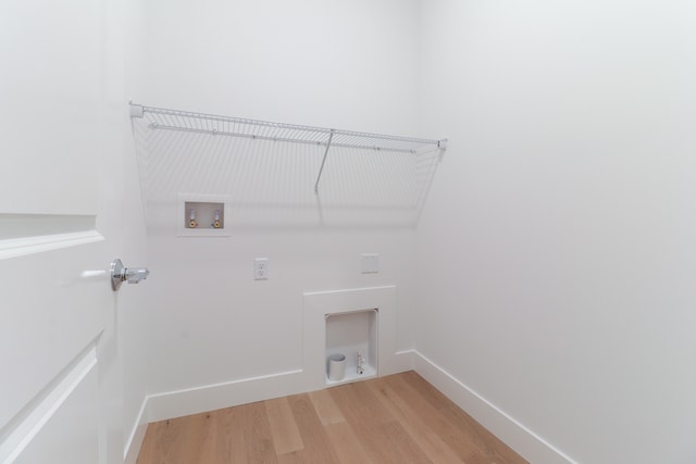 clothes washing area featuring washer hookup and light hardwood / wood-style flooring