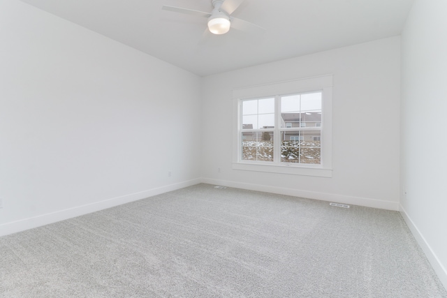 unfurnished room with light colored carpet and ceiling fan