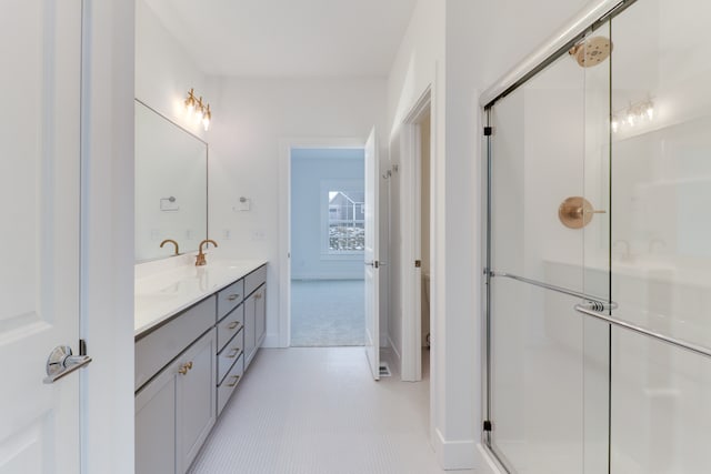 bathroom with double vanity, tile floors, and a shower with shower door