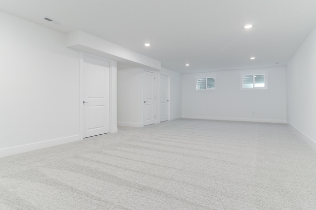 basement featuring light colored carpet