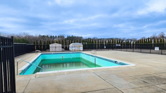 view of pool featuring a storage unit and a patio