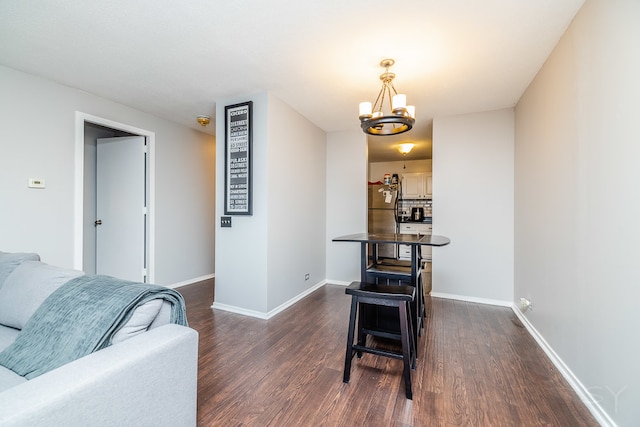 dining area featuring dark hardwood / wood-style flooring and a chandelier