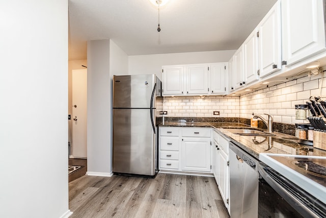 kitchen with sink, white cabinets, appliances with stainless steel finishes, and light hardwood / wood-style flooring