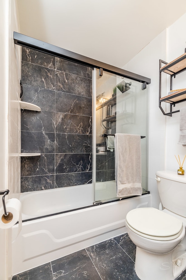 bathroom with toilet, shower / bath combination with glass door, and tile floors