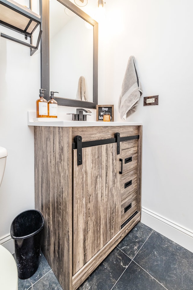 bathroom with tile floors, toilet, and vanity