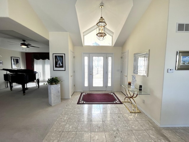 foyer entrance featuring high vaulted ceiling, baseboards, a ceiling fan, and visible vents
