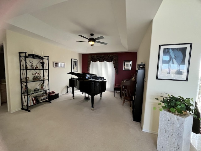 living area featuring baseboards, visible vents, light colored carpet, and a ceiling fan