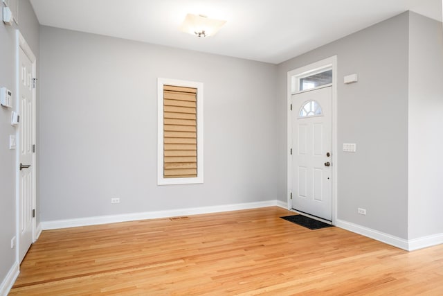 foyer entrance featuring light wood-style flooring and baseboards