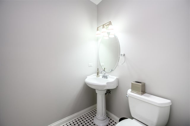 bathroom featuring toilet and baseboards