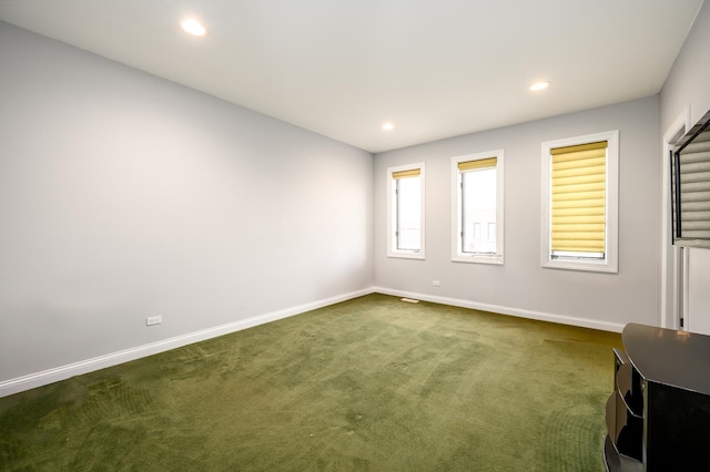 spare room with recessed lighting, dark carpet, and baseboards