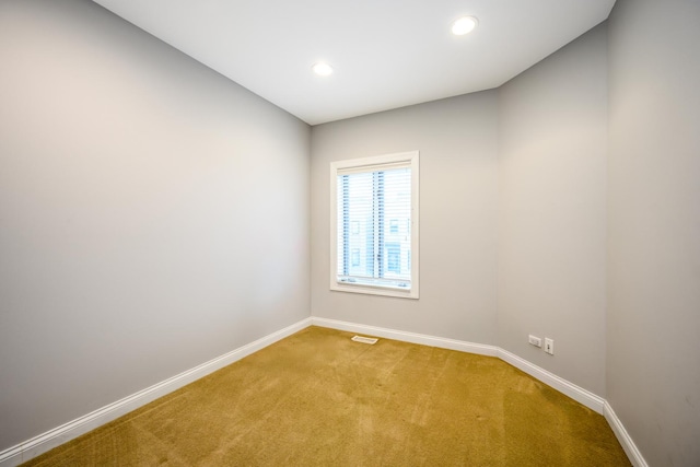 spare room with light carpet, recessed lighting, visible vents, and baseboards