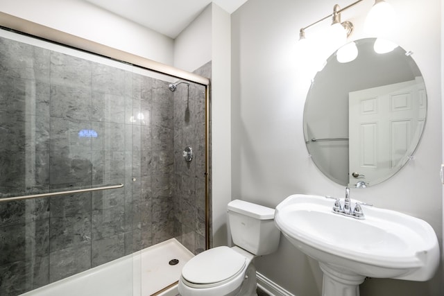 bathroom featuring a stall shower, a sink, and toilet