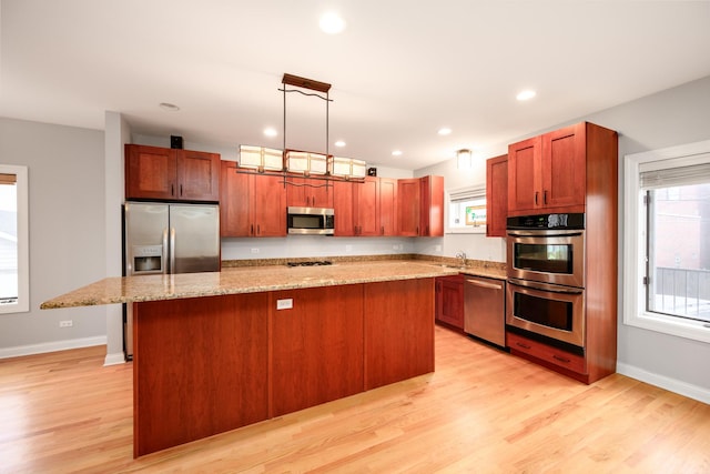 kitchen with recessed lighting, stainless steel appliances, baseboards, a center island, and light wood finished floors