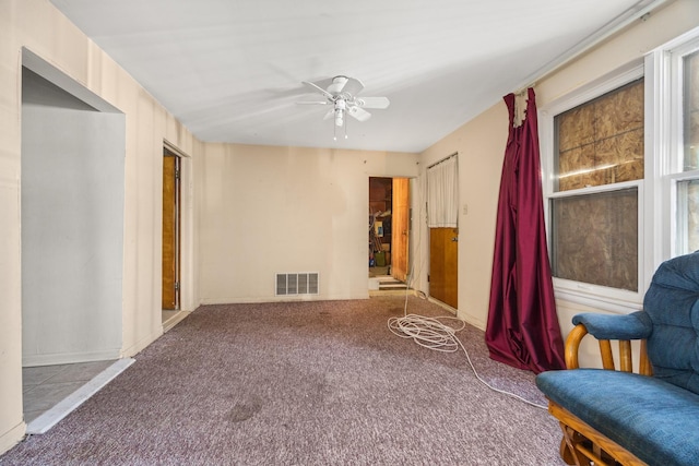 living area featuring ceiling fan and carpet flooring