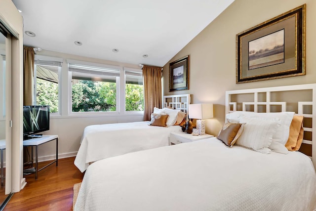 bedroom featuring wood-type flooring and vaulted ceiling