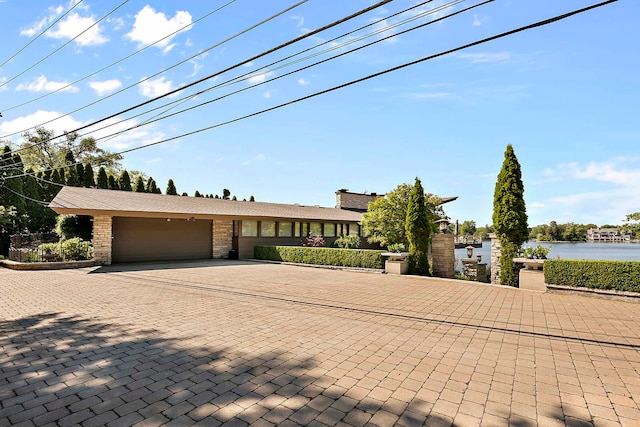 view of front facade with a garage and a water view