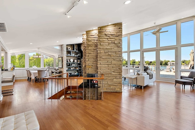 bar with rail lighting, hardwood / wood-style flooring, high vaulted ceiling, and ceiling fan