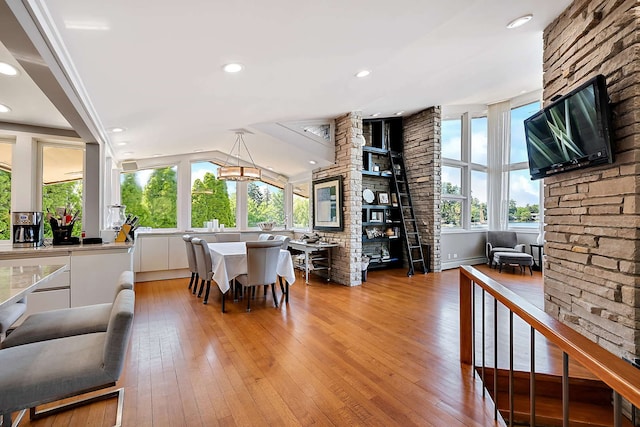 dining room featuring light hardwood / wood-style flooring, baseboard heating, and lofted ceiling