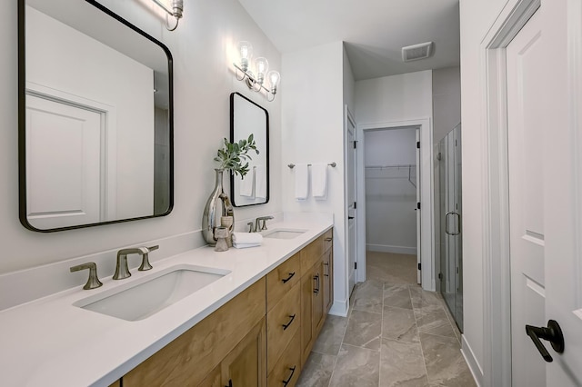 bathroom with vanity and a shower with shower door