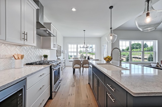 kitchen with white cabinetry, appliances with stainless steel finishes, sink, and wall chimney exhaust hood