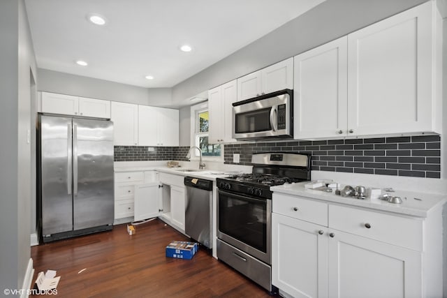 kitchen with sink, stainless steel appliances, white cabinetry, and dark hardwood / wood-style flooring