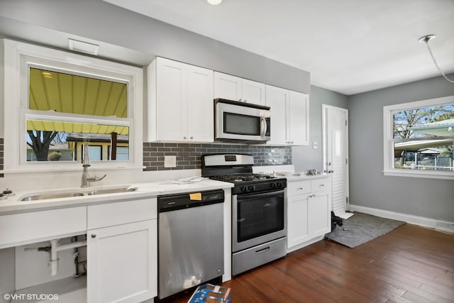 kitchen with dark hardwood / wood-style floors, stainless steel appliances, white cabinetry, and sink