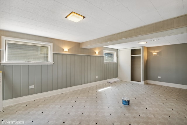 spare room featuring light tile floors and wooden walls