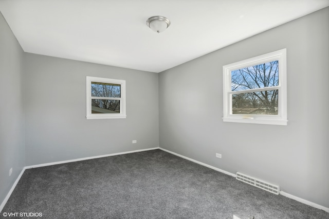 spare room with dark carpet