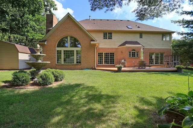 back of property featuring a wooden deck, a yard, and a storage shed