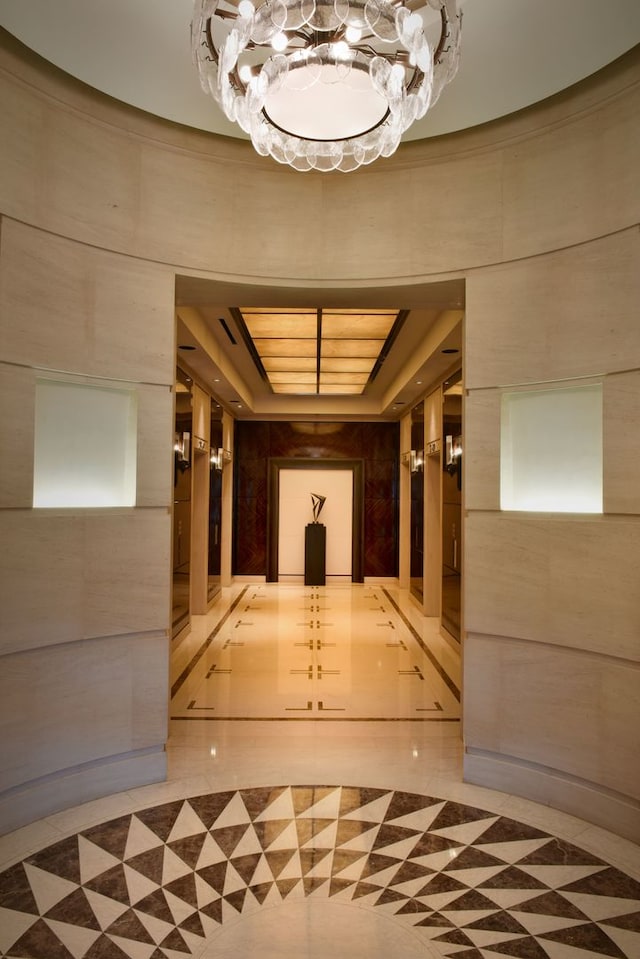 interior space with a tray ceiling and light tile floors