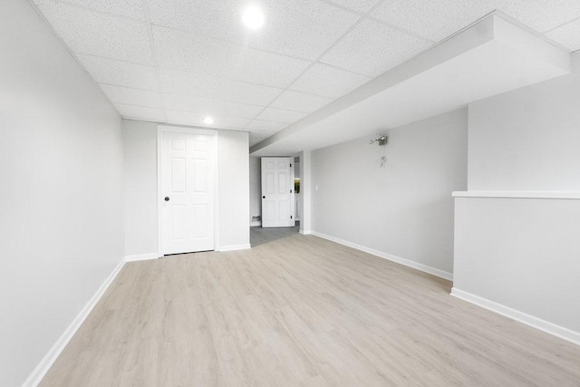 interior space featuring a drop ceiling and light wood-type flooring