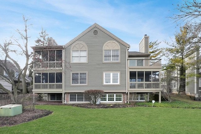 back of house with a balcony, a lawn, and a sunroom