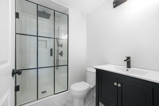 bathroom featuring an enclosed shower, vanity, and toilet