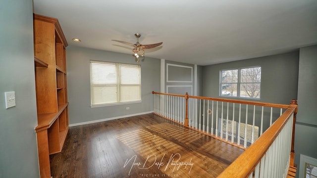 spare room with dark wood-type flooring and ceiling fan