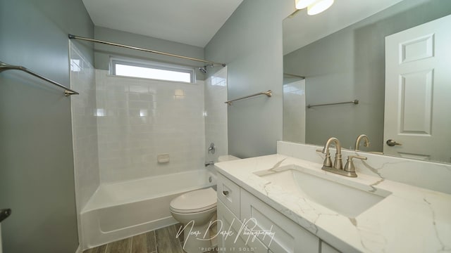 full bathroom featuring tiled shower / bath combo, vanity, hardwood / wood-style flooring, and toilet