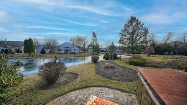 view of home's community featuring a lawn and a water view