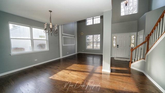 entrance foyer featuring a high ceiling, dark hardwood / wood-style floors, and a notable chandelier