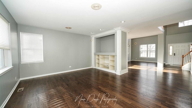 unfurnished living room featuring dark hardwood / wood-style floors and built in features