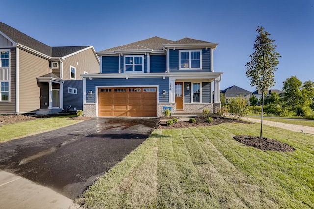 view of front of property with a porch, a front yard, and a garage